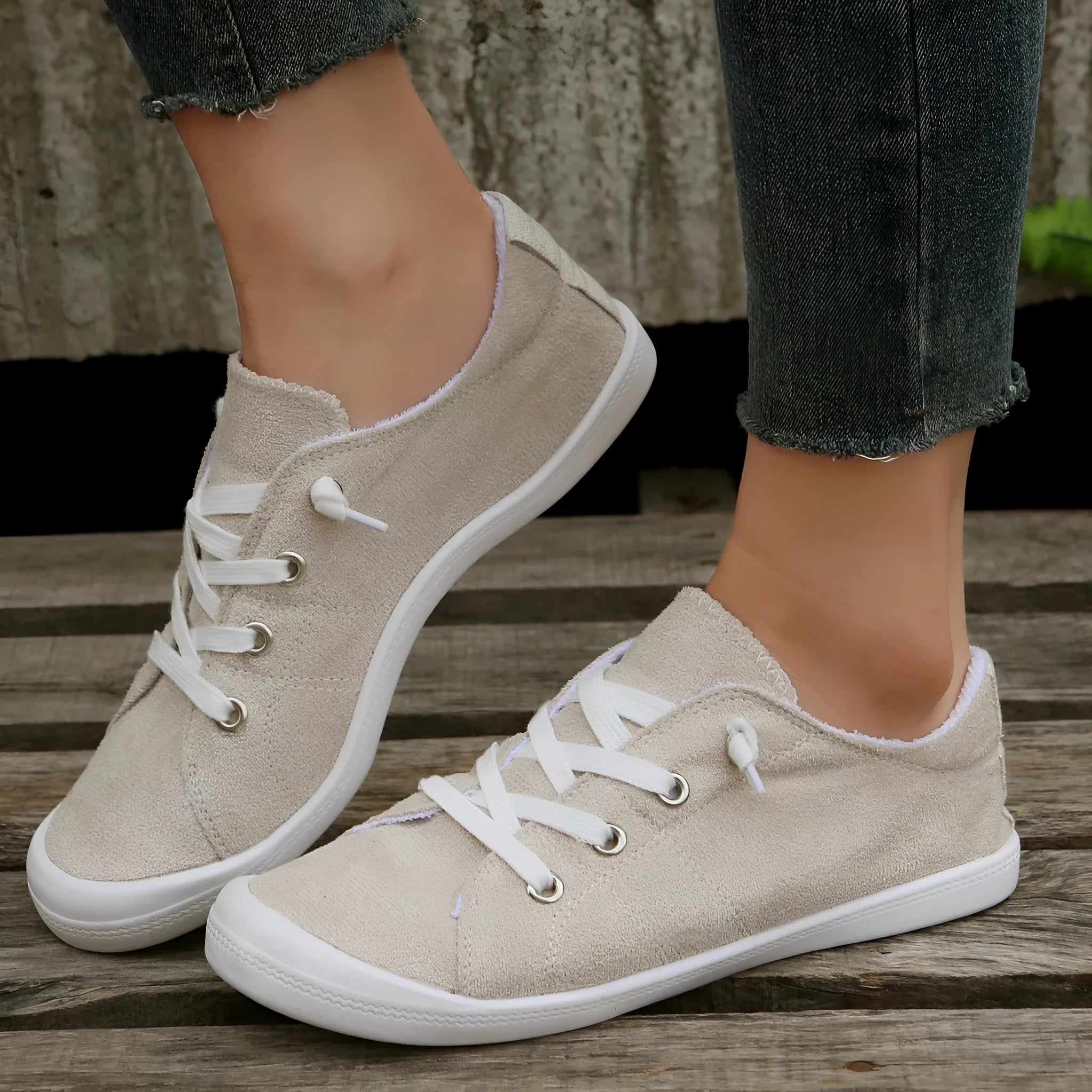 Women's creamy white casual low-top sneakers with fabric upper and rubber sole on a neutral background.