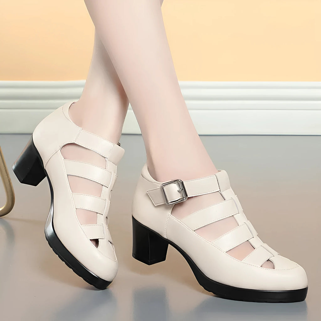 Women's beige closed toe sandals with chunky heel, woven ankle-strap buckle, and back zipper on a plain background