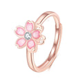Cherry blossom rotatable ring with rose gold finish, adjustable opening, and silver base shown on a finger