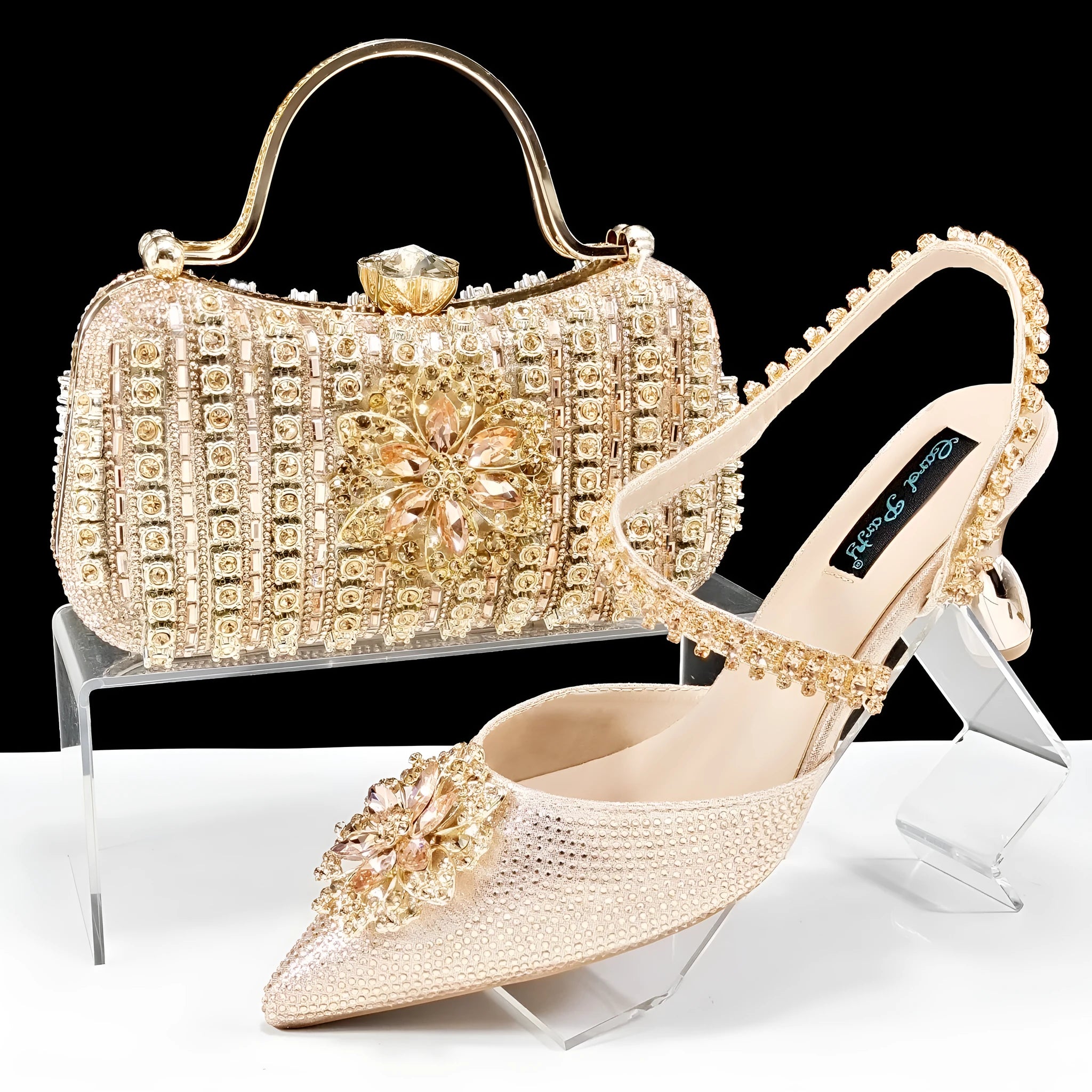 Women's black high heel shoe and matching clutch bag with floral rhinestone decoration and chain strap.