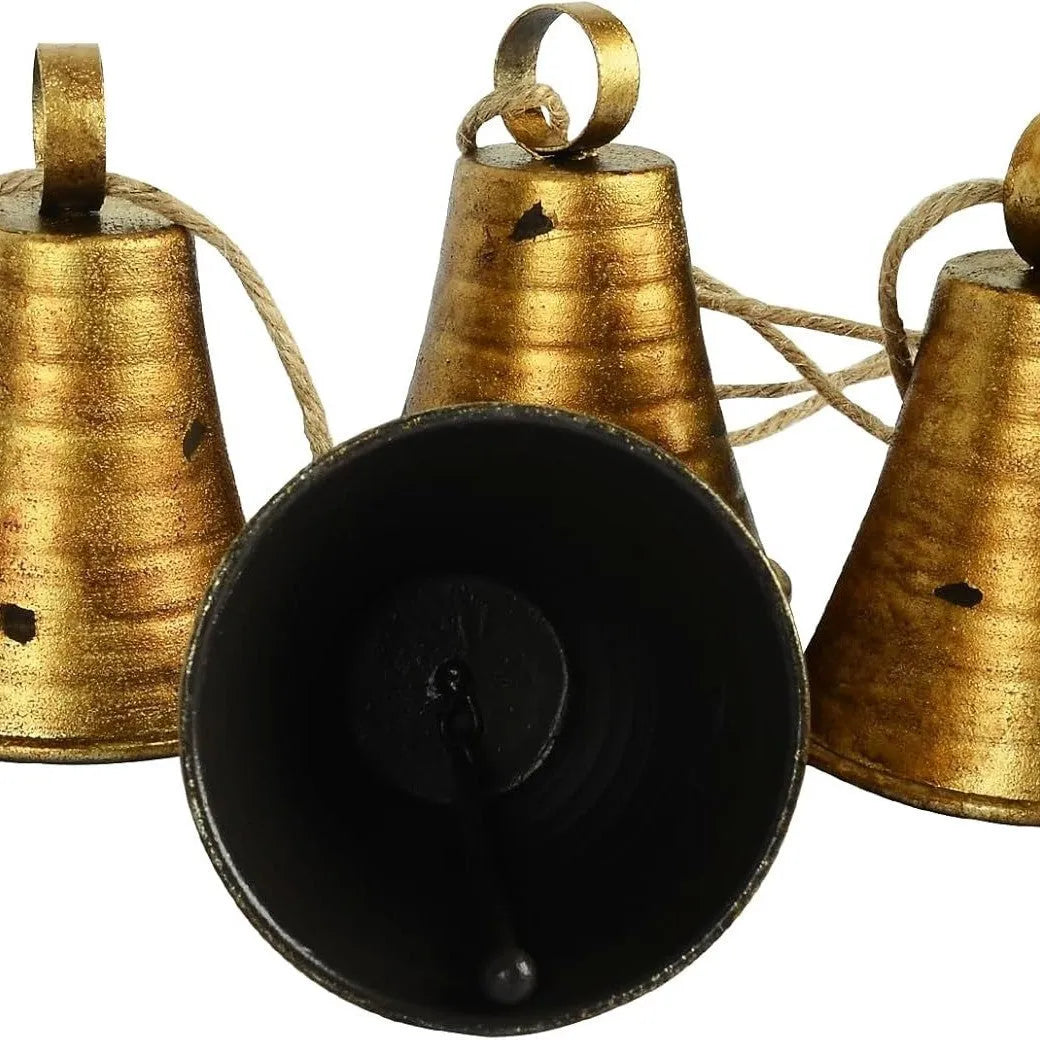 Four handmade metal bells in retro country style, each 11.5x8.5 cm, on a wooden surface