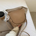 Woven pattern PU leather crossbody bucket bag worn underarm, shown in khaki colour.