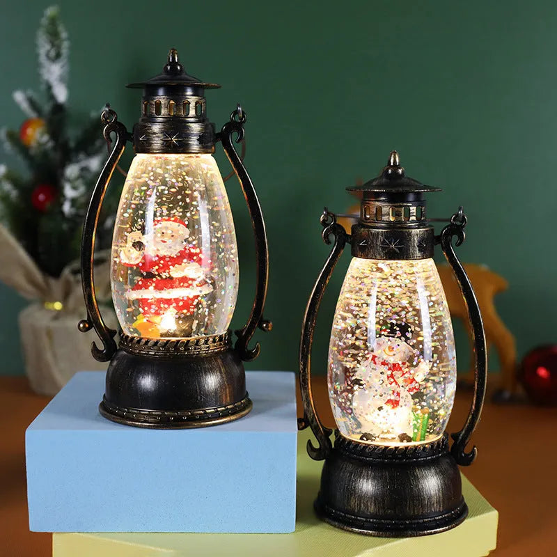 Plastic crystal ball LED oil lamp Christmas decoration showing internal snowman scene on a desktop.