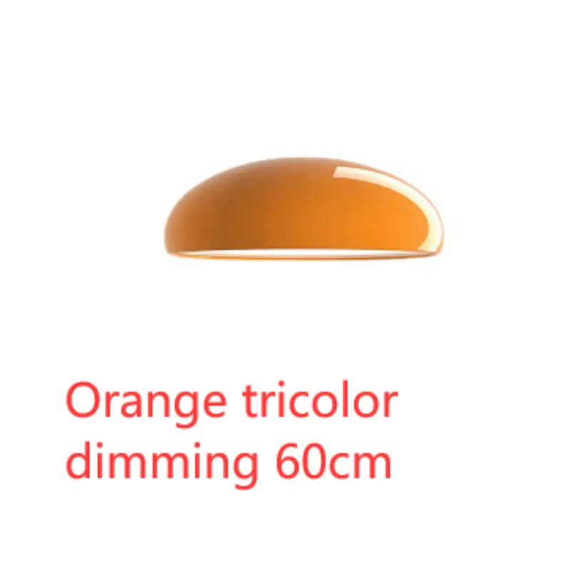 Danish iron pendant lamp in orange with adjustable cable hanging over a restaurant table.
