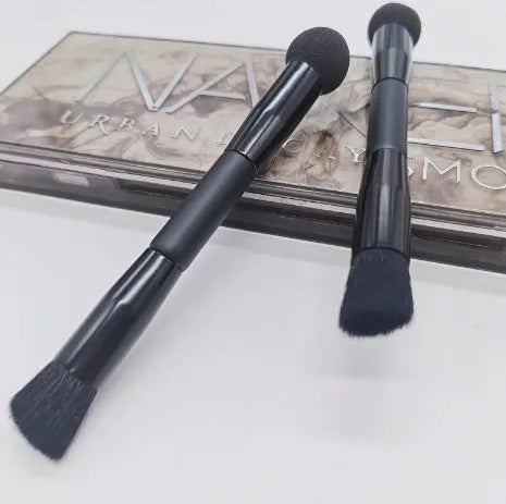 Elegant black double-headed makeup brush with a synthetic fibre brush and a miter sponge on a wooden handle.