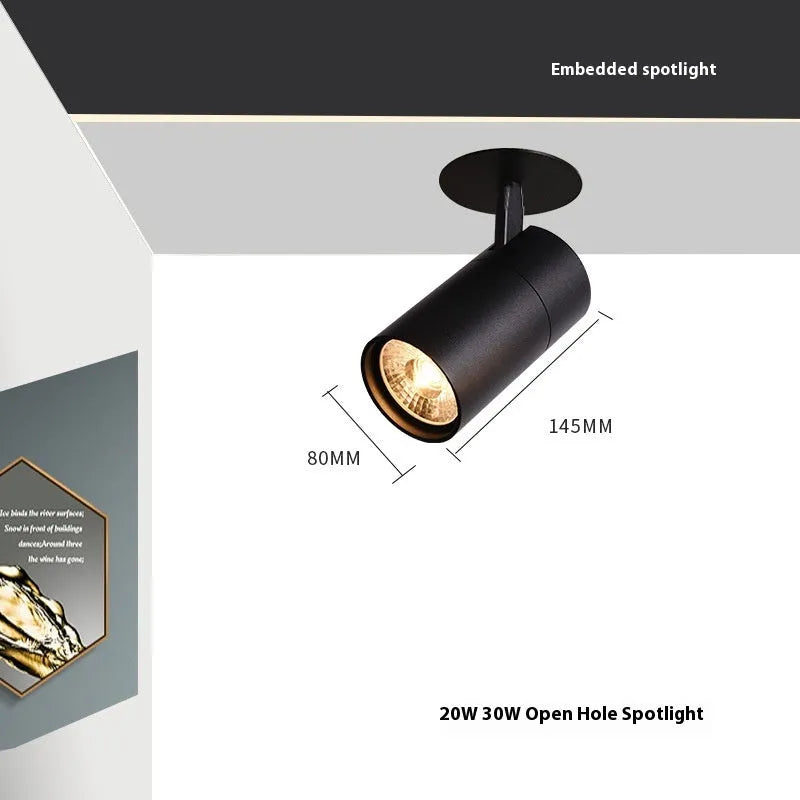 Black recessed cylinder LED spotlight installed in a ceiling track, showing adjustable head.