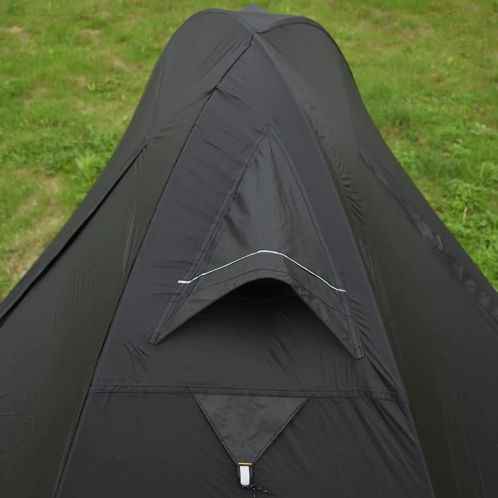 Single person hiking tent in orange pitched in a forest, showing aluminium poles and double-layer design with mesh panel.