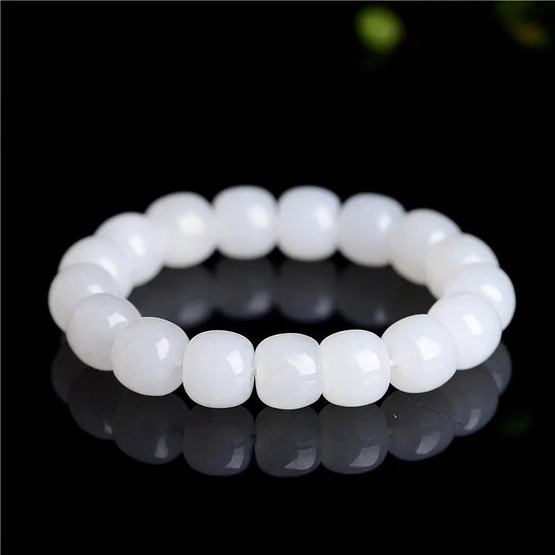 White Hetian jade barrel bead bracelet showing smooth, polished beads on a wrist.