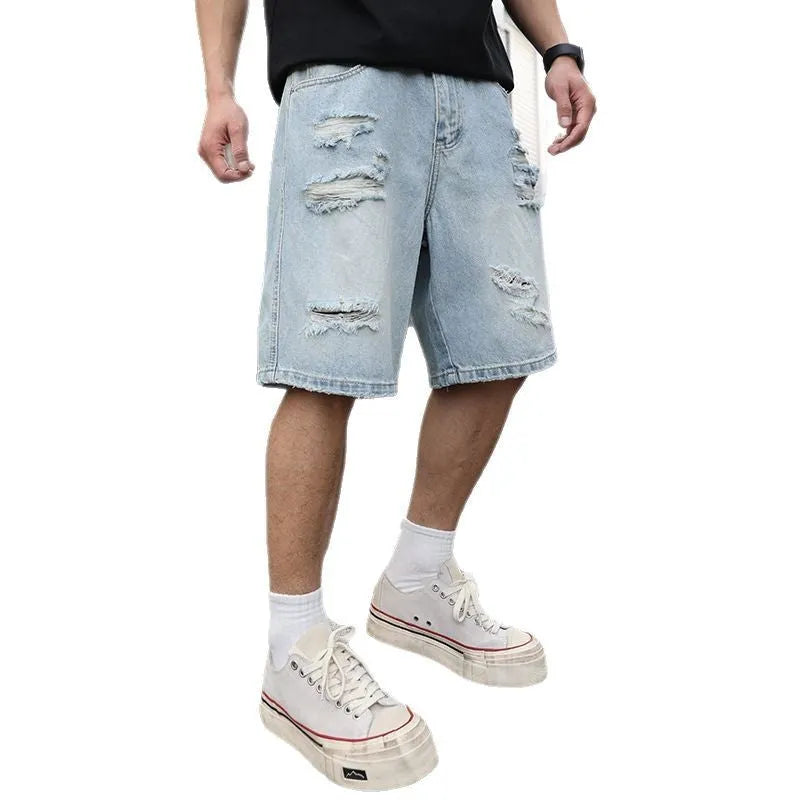 Men's light blue ripped denim shorts with a loose, straight leg fit on a plain background.