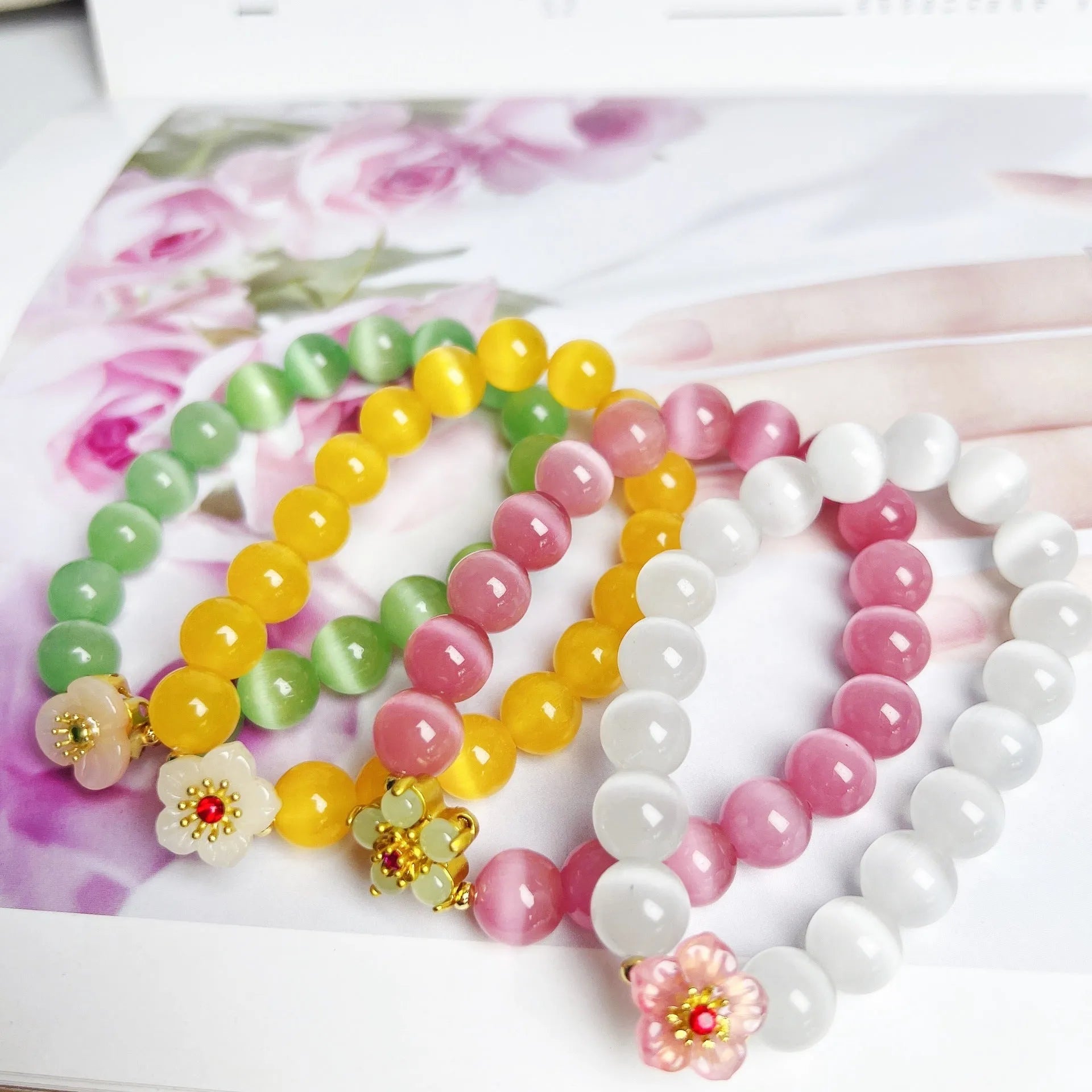 Handmade glass bead bracelet with floral design in green, pink, white, or yellow.