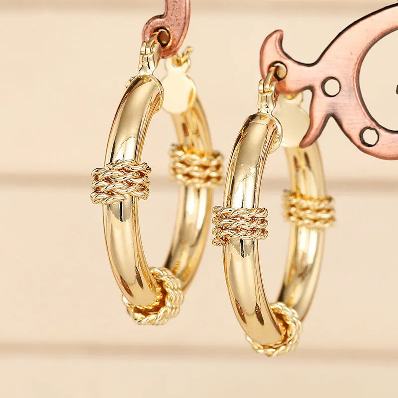 Geometric ring-shaped copper ear clips for women in a polished golden finish.