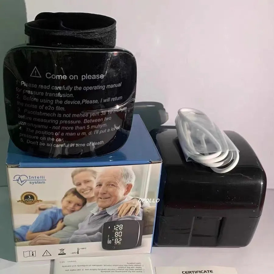 Black wrist blood pressure monitor with USB charging port on a table.