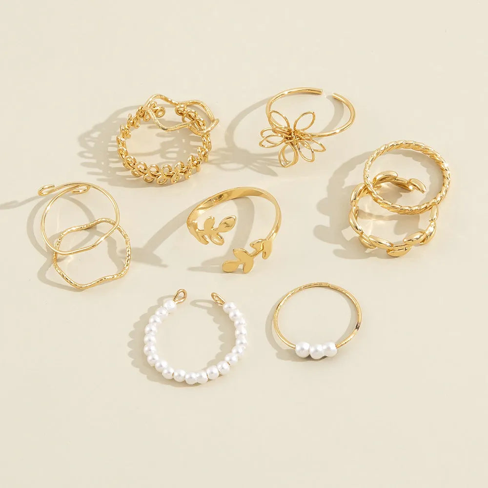 Gold openwork flower alloy ring with glossy electroplated finish on white background