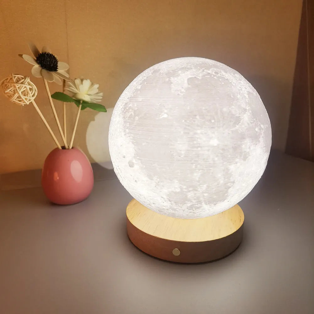 Rotating moon night lamp on a wooden base showing three colour light modes.