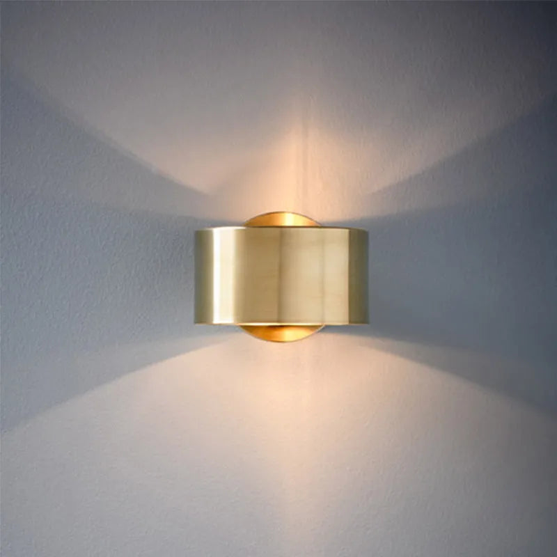 Modern iron wall lamp with copper gold finish, 15cm diameter on a white wall