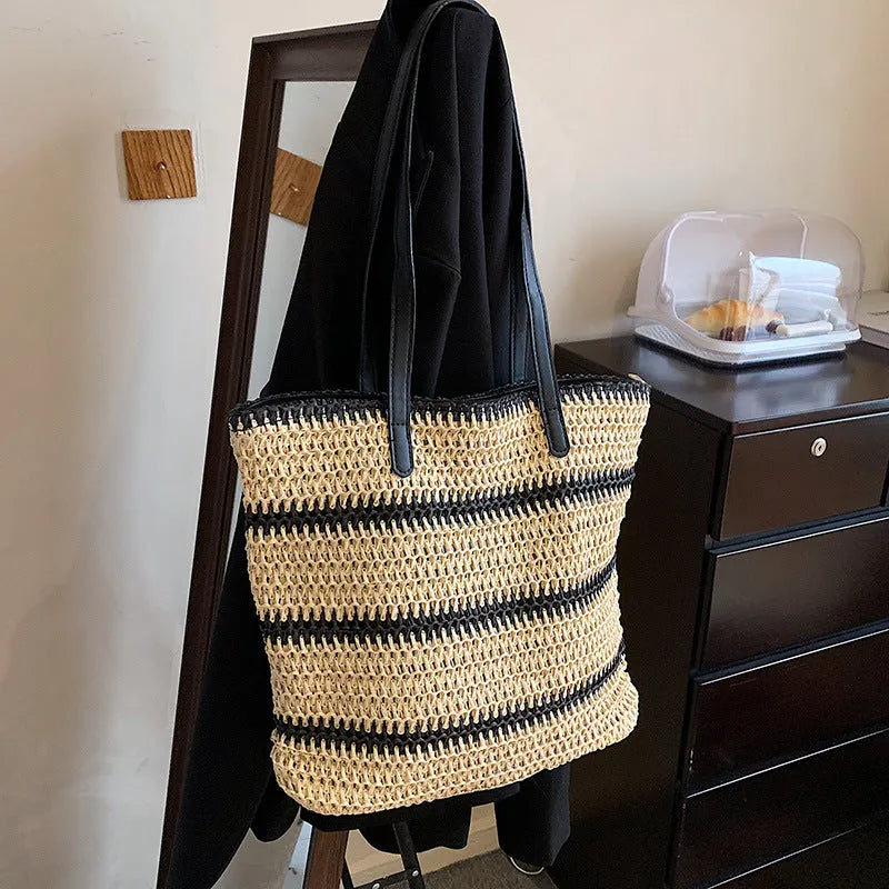 Large striped straw woven handbag with 64cm shoulder strap and polyester lining, shown in khaki or black