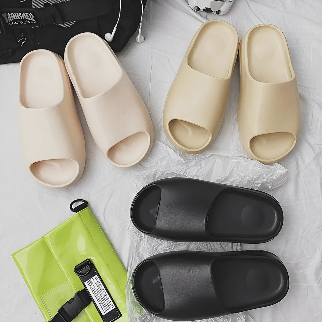 Women's thick-soled EVA beach slippers in beige, shown on a sandy background.