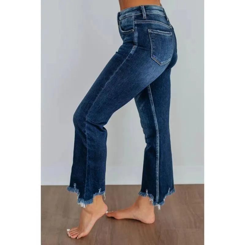 Women's solid colour denim jeans in dark blue showing hand-worn texture and casual fit.