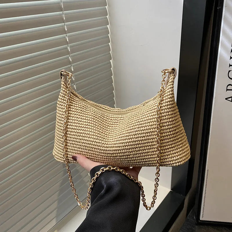 Khaki woven straw crossbody handbag with square shape and crossbody strap.