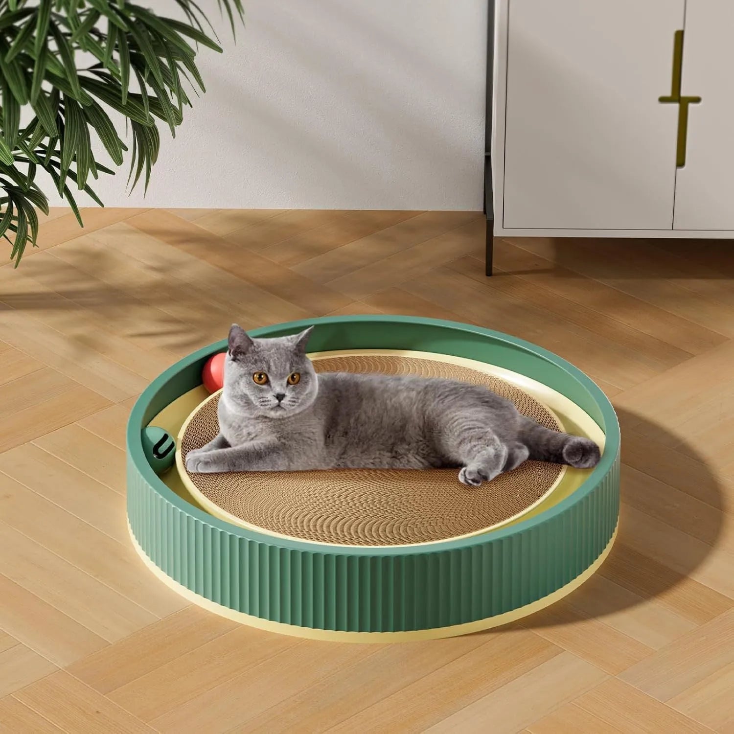 Large circular green cat scratching board with integrated ball toys measuring 45cm diameter