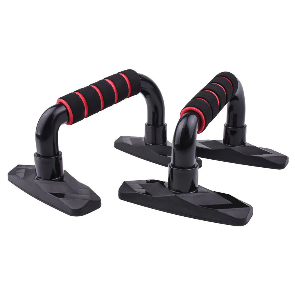 A pair of I-shaped black push up bars with textured PP sponge grip handles on a grey floor.