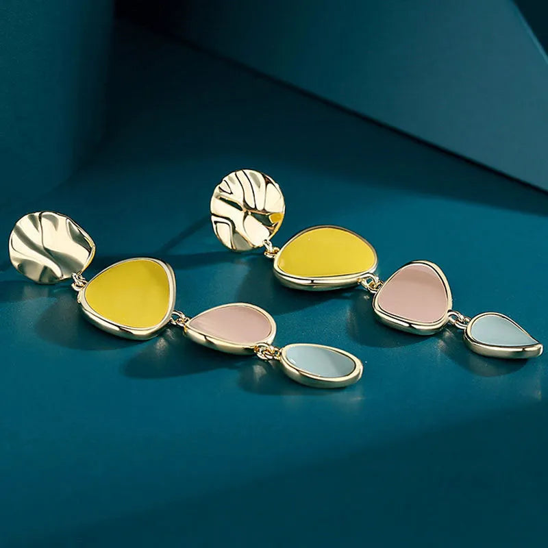 A pair of simple disc-shaped earrings with a morandi three-colour oil-drip finish and sterling silver posts.