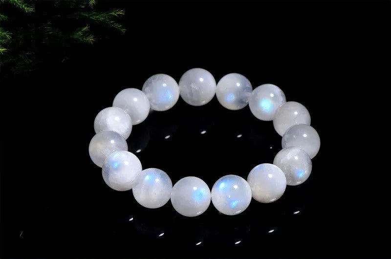 Natural blue moonlight round bead moonstone bracelet on a wrist, showing polished stones.
