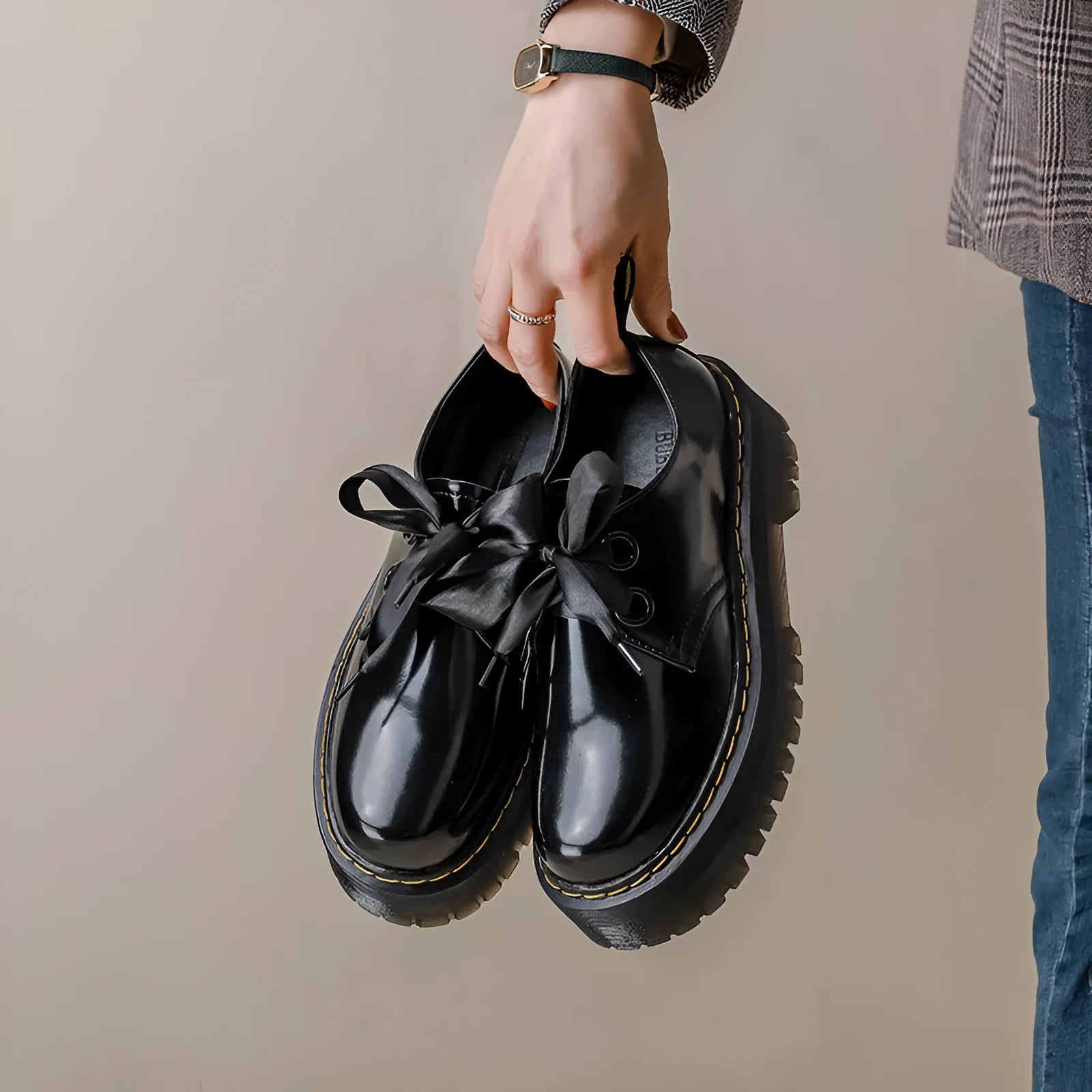 Women's black leather shoes with a thick sole, cross strap, and lace-up closure.