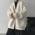 Women's loose-fitting knitted cardigan top coat in black, showing long sleeves and solid colour design.