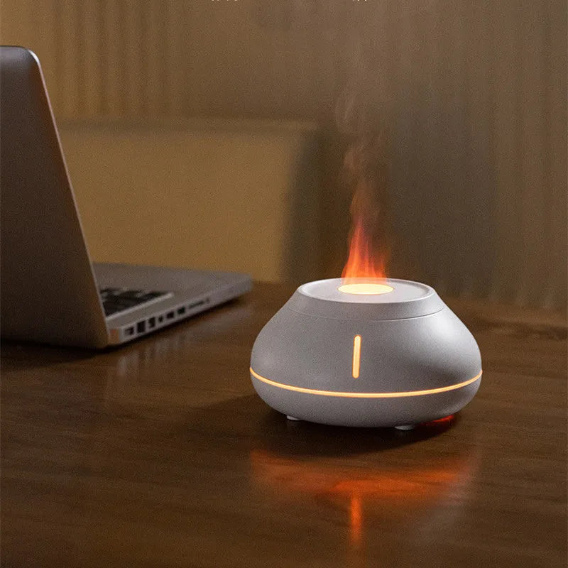 White round desktop aroma diffuser humidifier with colourful LED flame effect light on.