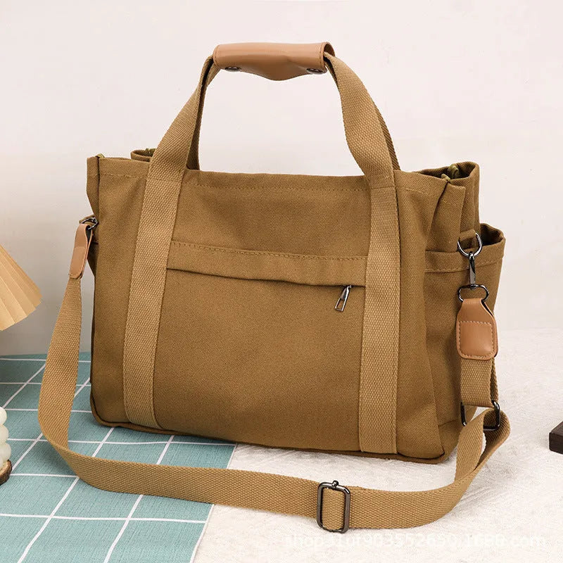 Canvas tote bag with internal organisation pockets for phone, documents, laptop, and camera in horizontal square shape