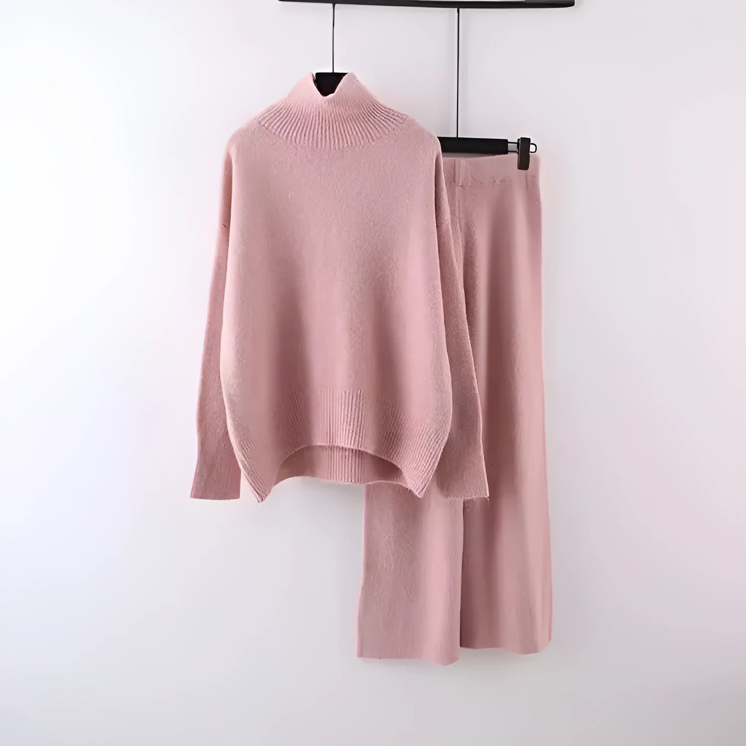 Women's beige acrylic knit long-sleeve sweater and matching wide-leg trousers set on a hanger.