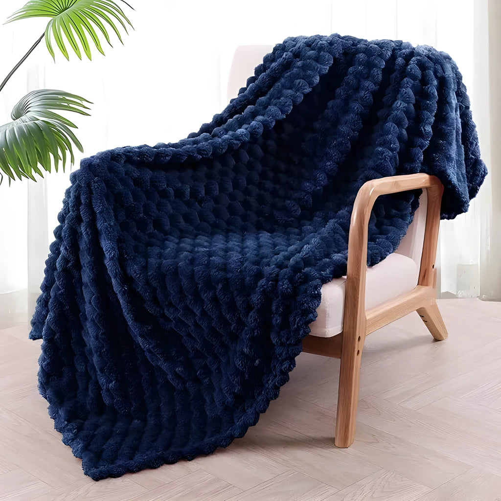 Soft camel-coloured plaid children's blanket folded on a wooden chair.