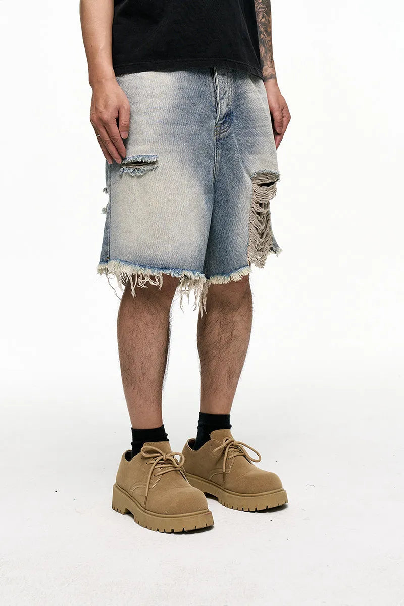 Light blue washed denim shorts for men with a baggy fit and mid waist, shown on a hanger.