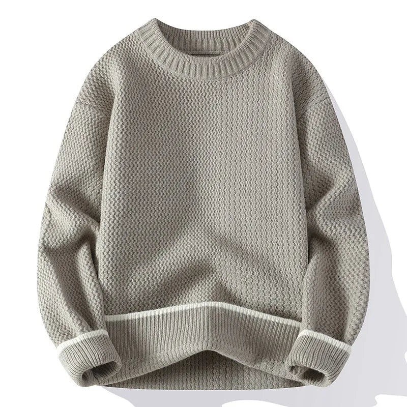 A man wearing a grey loose-fitting round neck casual pullover sweater.