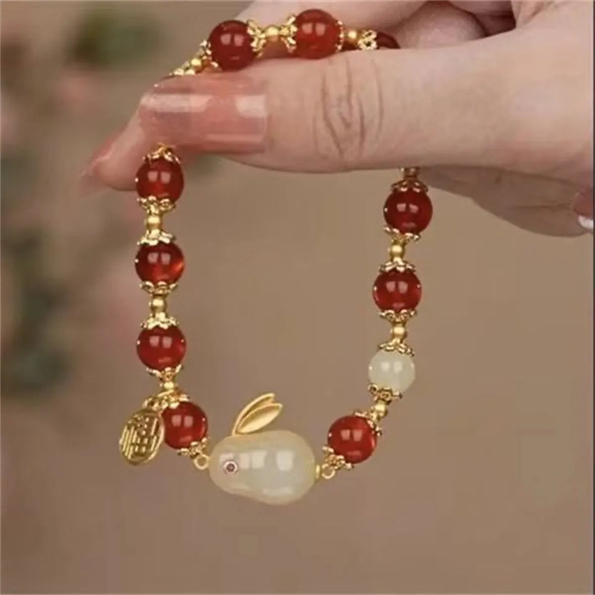 Handmade unisex glass beaded bracelet with rabbit charm on elastic cord.