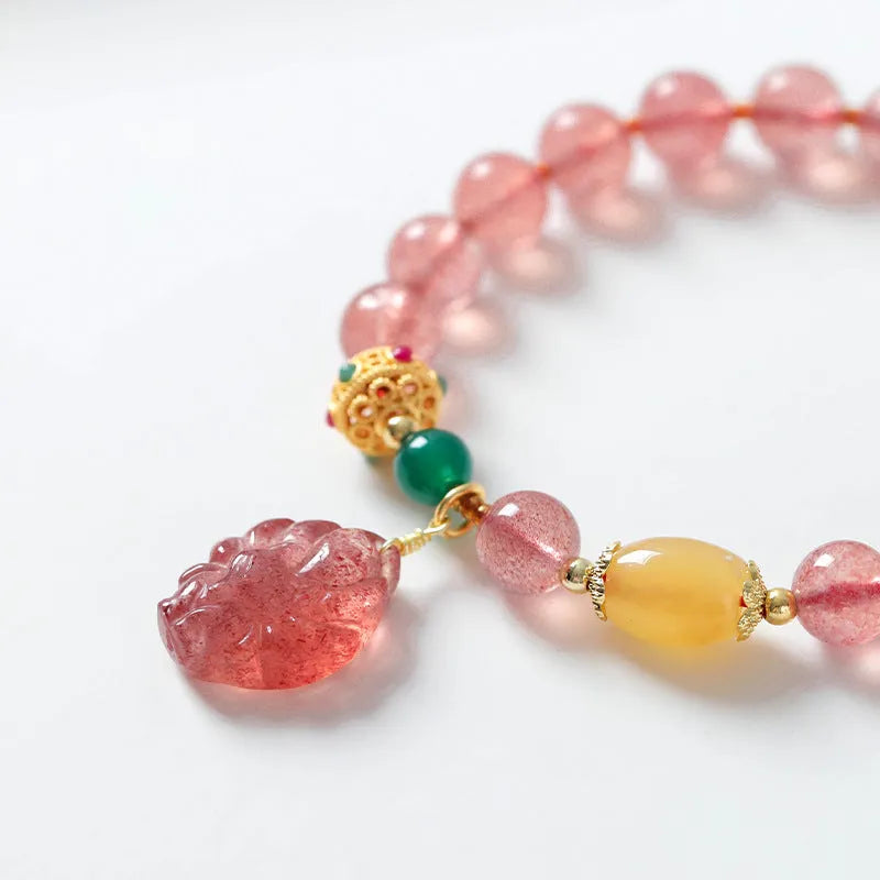 Women's Nine Tail Fox style strawberry quartz crystal beaded bracelet on wrist