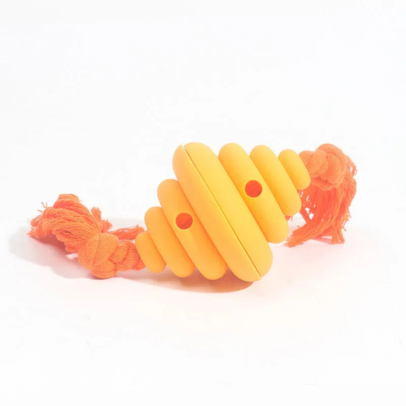 Green and yellow silicone dog ball with knotted rope attached, showing food dispenser openings.