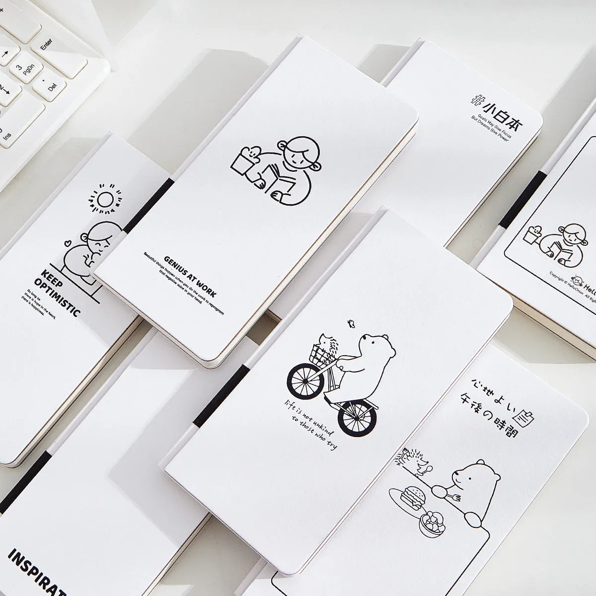 Small white paper notebook with plaid pages, mesh cover, and a pair of decorative stickers.