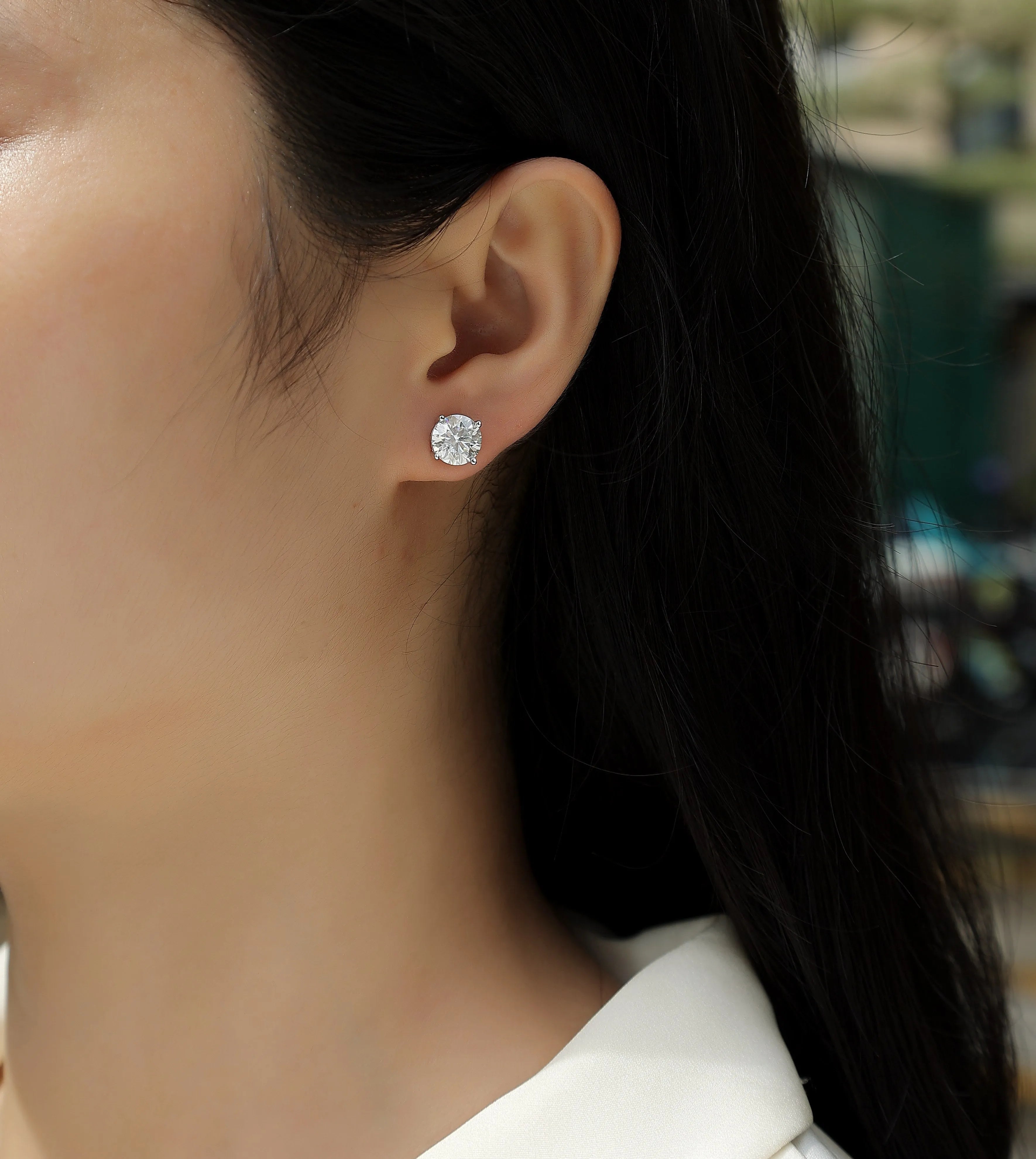 Pair of moissanite stud earrings with platinum-plated S925 silver settings, on a gift box, available in black or transparent stones