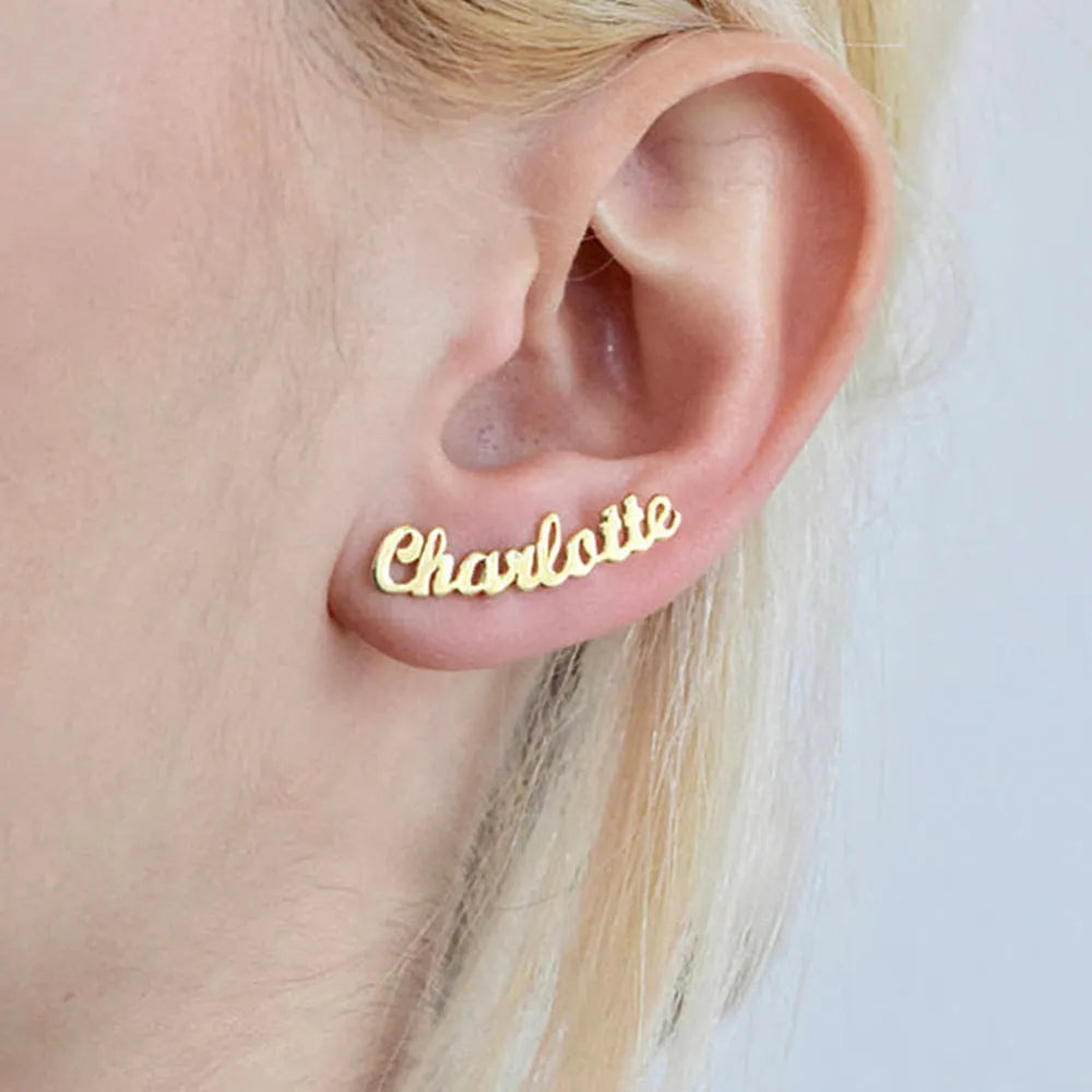 Custom English letter name earrings in rose golden finish on a plain background