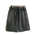 Man wearing solid colour distressed cotton shorts with a loose casual straight-leg fit