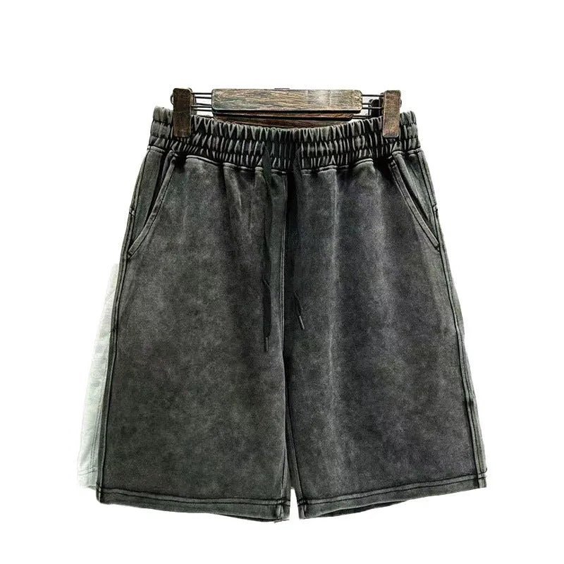 Man wearing solid colour distressed cotton shorts with a loose casual straight-leg fit