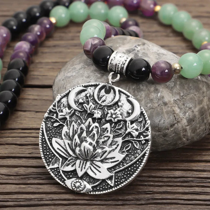 Yoga lotus pendant necklace and bracelet set with stone beads on a white background