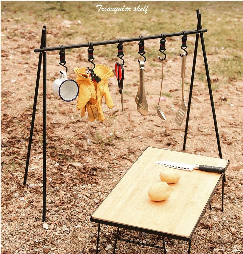 Aluminium alloy portable folding clothes drying rack with triangular frame and top tray, set up outdoors.