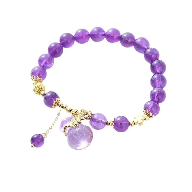 Purple amethyst crystal bracelet with money bag charm and peace buckle on woman's wrist