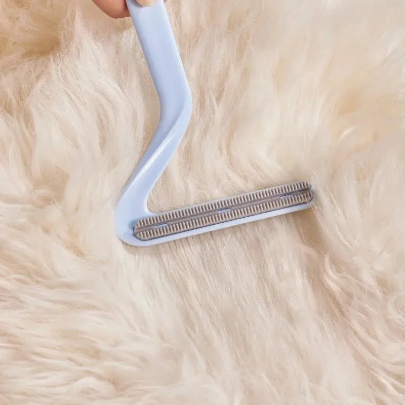 Double-sided pet hair removal comb in blue for removing cat and dog fur from beds and upholstery