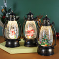 Plastic crystal ball LED oil lamp Christmas decoration showing internal snowman scene on a desktop.