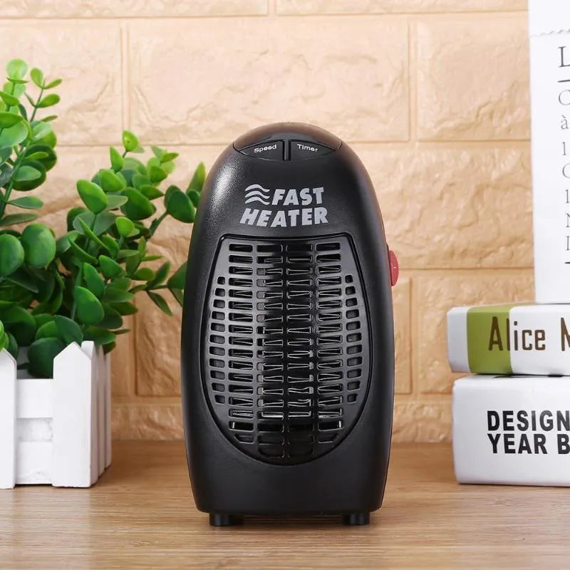 Black mini electric ceramic heater with digital display and a rotating three-prong plug on a desk.