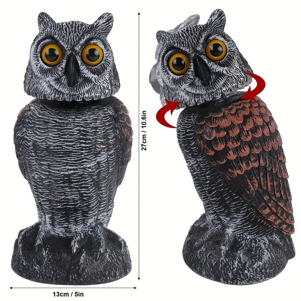 Plastic artificial owl bird scarer with a shaking head, shown in a garden setting.